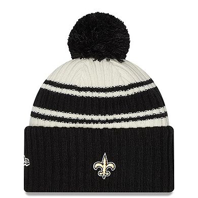 Men's New Era Cream/Black New Orleans Saints 2022 Sideline Sport Cuffed Pom Knit Hat