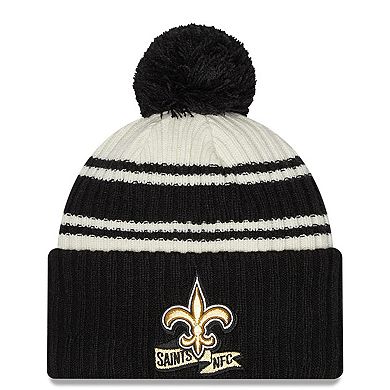 Men's New Era Cream/Black New Orleans Saints 2022 Sideline Sport Cuffed Pom Knit Hat