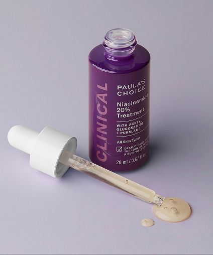 Paula's Choice Niacinimide 20% Treatment bottle with the cap off and dropper laid next to it.