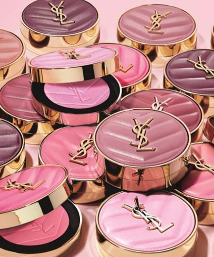 Collection of Yves Saint Laurent makeup containers stacked on top of each other.