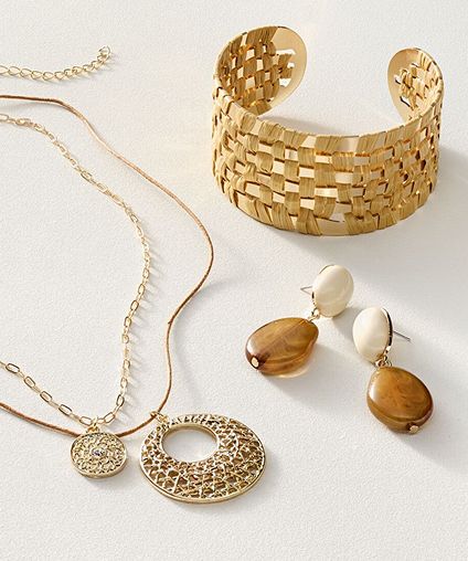 Assorted earings, necklaces, and a bracelet arranged on a gray background.