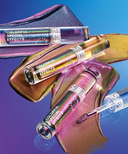 Three different shades of lip gloss spread across the background with corresponding containers laid on top.