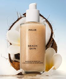 Bottle of PHLUR Beach Skin in front of a coconut.