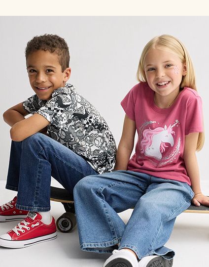 Kids smiling on a skateboard.