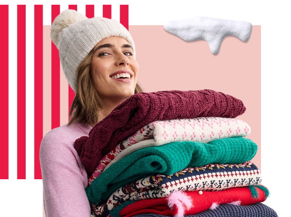 Woman carrying a stack of holiday sweaters