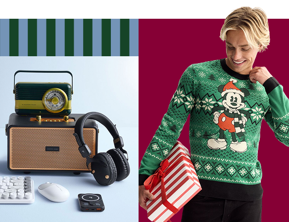Young man holding a present, standing next to an electronics assortment