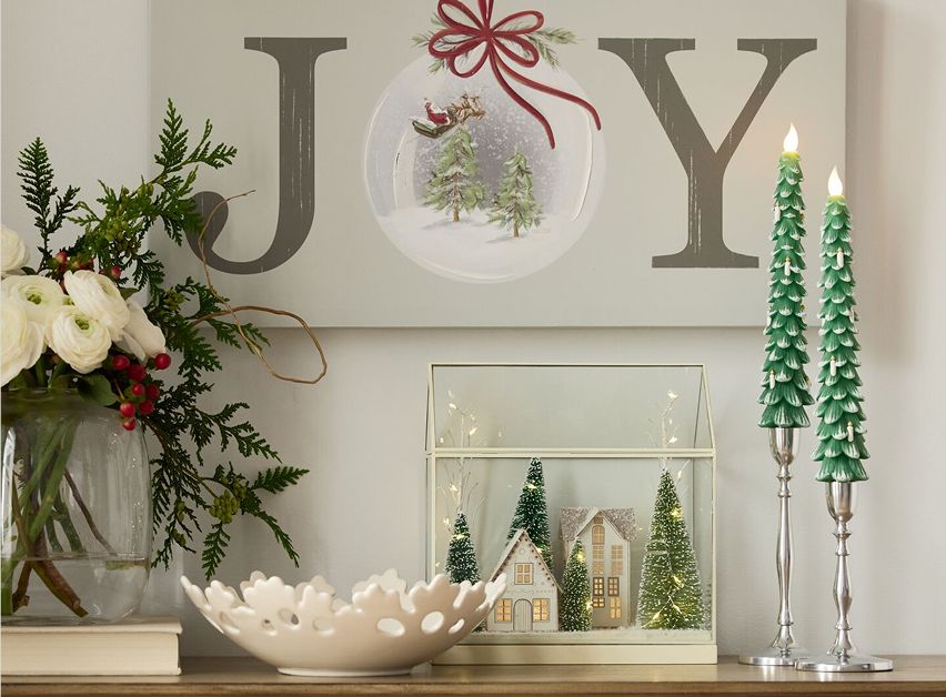Holiday decor with JOY sign and candles.