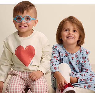 Two children wearing various Little Co gear smiling for the camera.