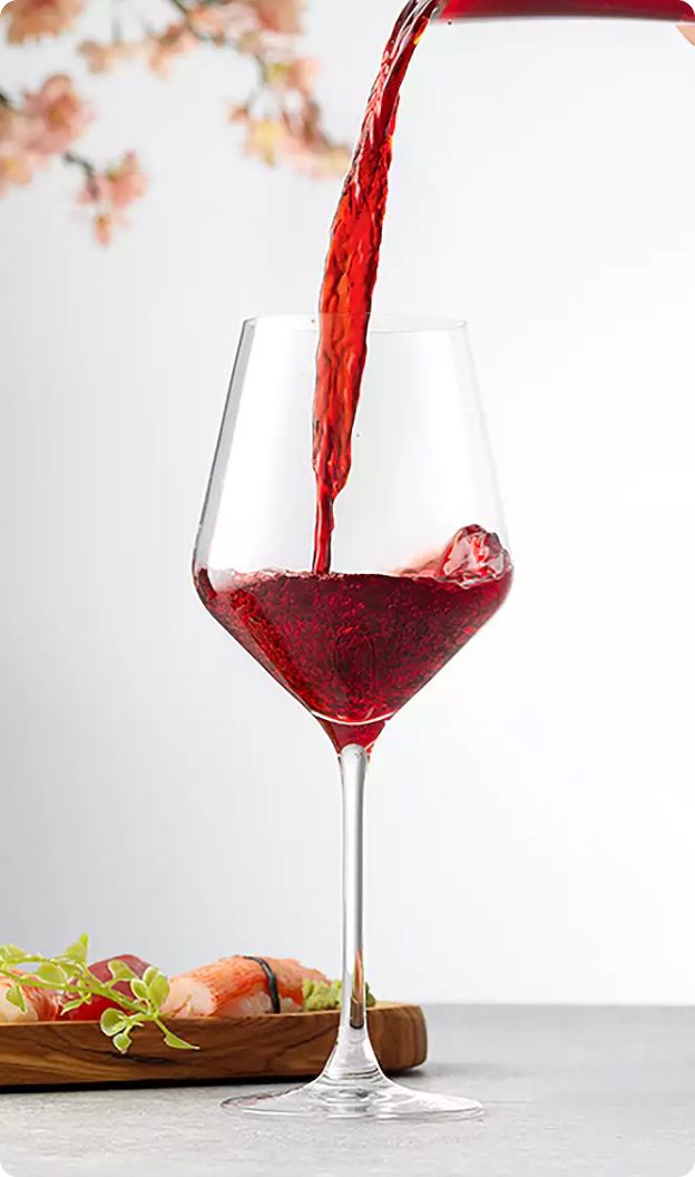 Wine glass with wine being poured into it.