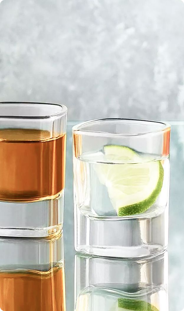 Two shotglasses filled with different liquids.