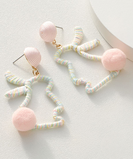 Two bunny shaped earrings with pink puffy tails.