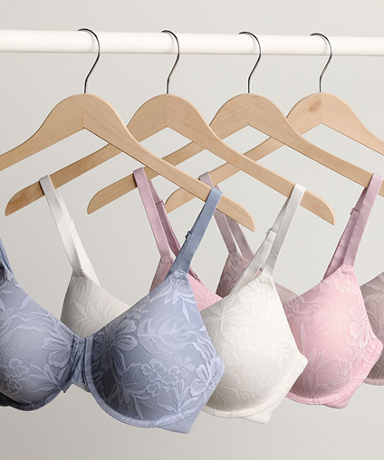 Different colored bras hanging on a clothes rack.