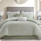 Bedroom scene with bed, tables on either side and lights on each table.