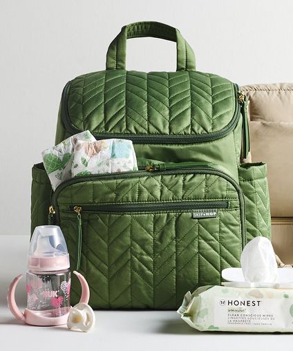 Green diaper bag with a bottle and moist wipes positioned in front.