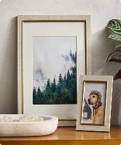 Neutral colored picture frames and home decor arrangement.