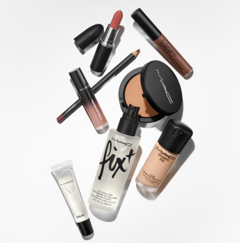 Assorted MAC Cosmetics products laid out over a white background.