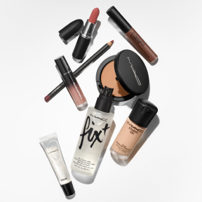 Assorted MAC Cosmetics products laid out over a white background.