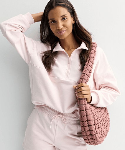 Woman in a pink outfit carrying a darker pink purse.