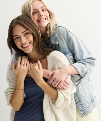 Two women embracing and smiling at the camera.