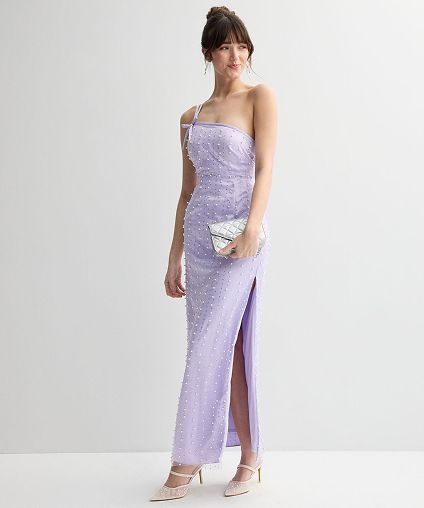 Woman in a purple prom dress holding a white purse.