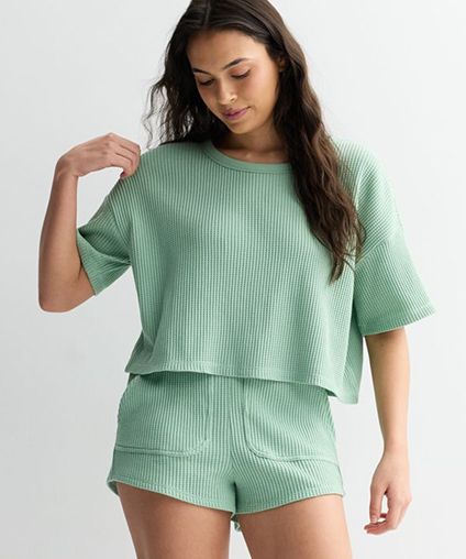 Woman wearing a matching set of green shorts with a green top.