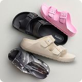 Assortment of various colored sandals over a gray background.