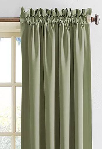 Green curtains hanging on a rod in front of a window.