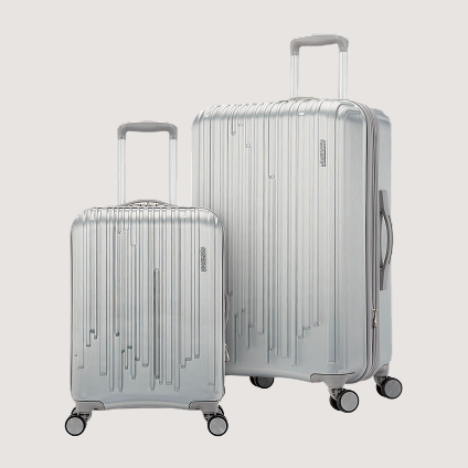 Two pieces of silver rolling luggage, one larger than the other.