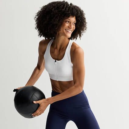Model in athletic gear throwing an exercise ball.
