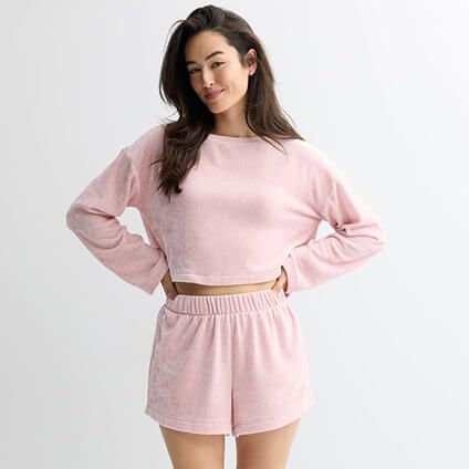 Model wearing a pink pajama top and matching shorts.