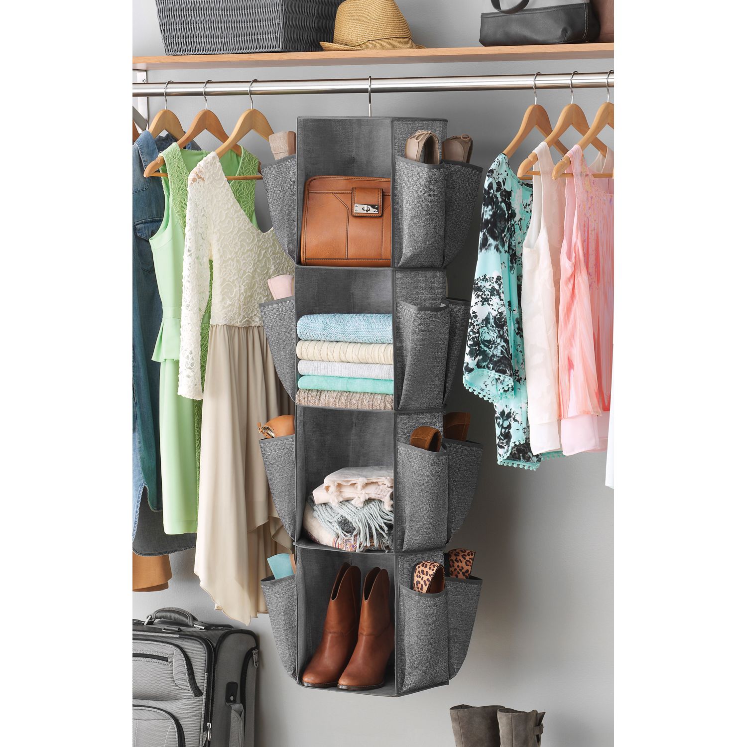 A grey closet organizer with shoes and accessories in it hanging in a closet
