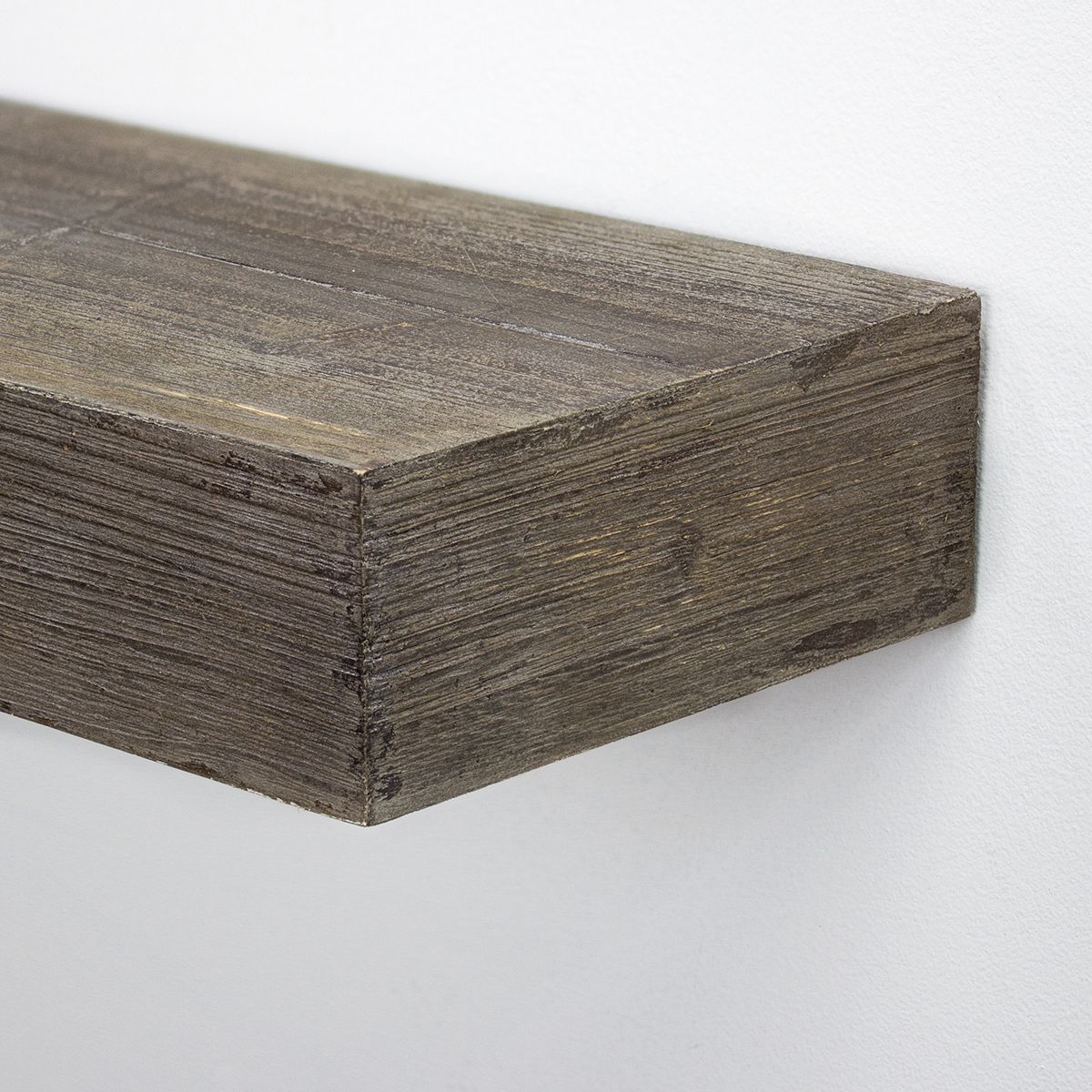 Close-up of rustic wood shelf edge mounted to wall