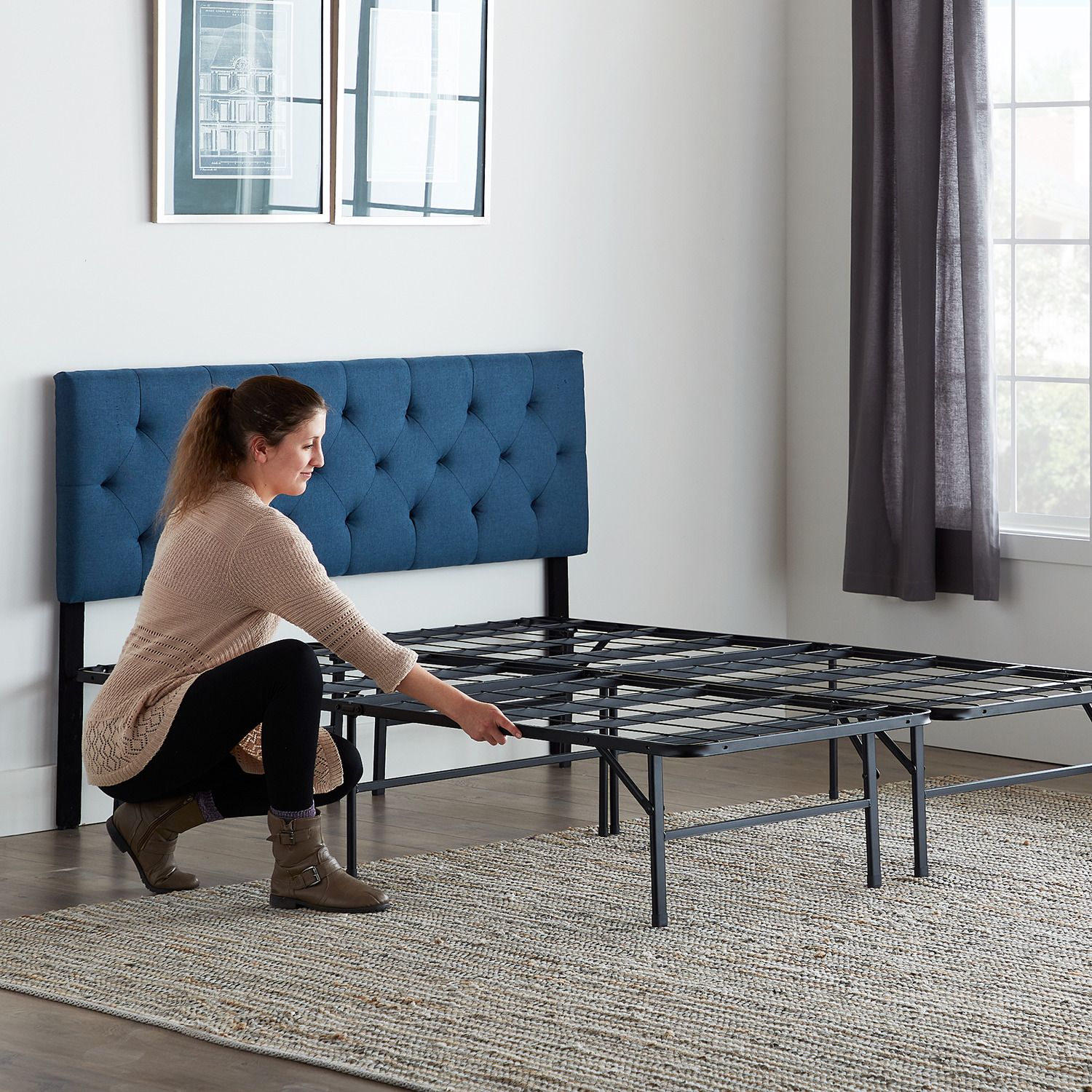 White mattress on black platform bed frame with deep blue tufted headboard