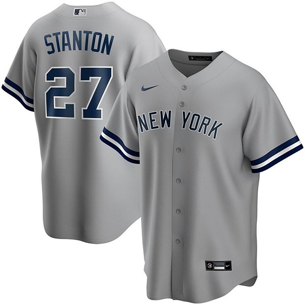 Giancarlo Stanton holds up his new No. 27 Yankees jersey.