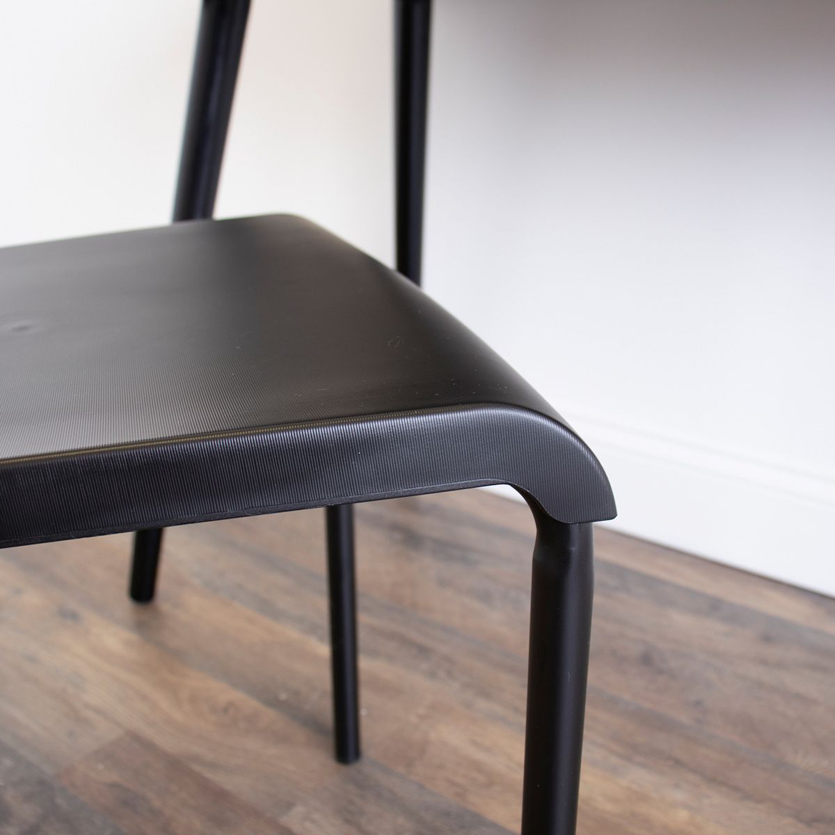 Close-up of black upholstered seat edge on industrial desk chair