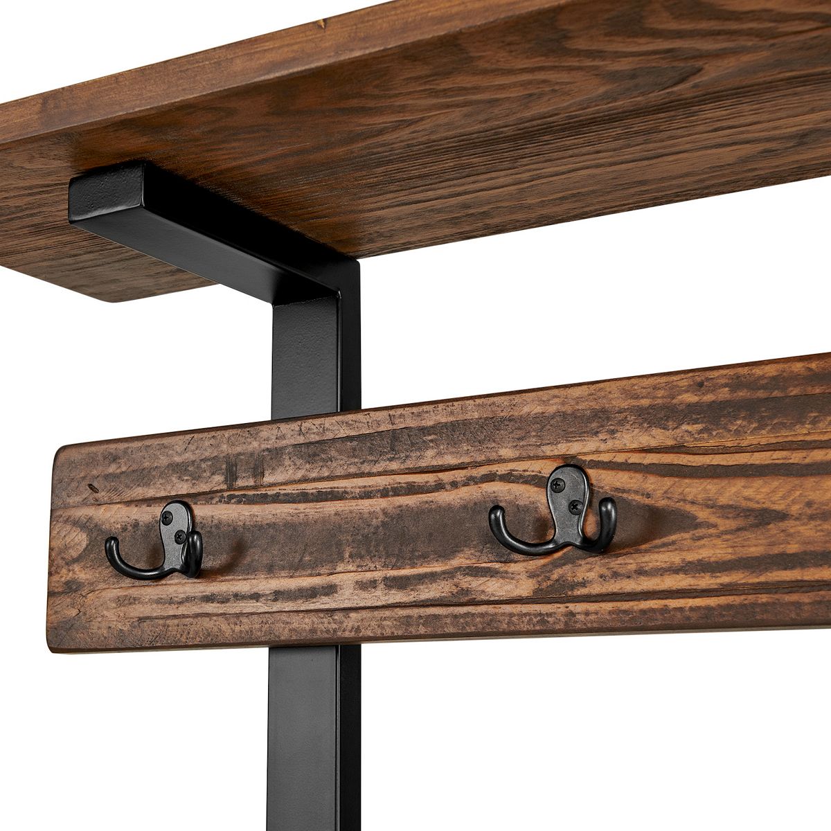 Close-up of three black coat hooks on wood rail