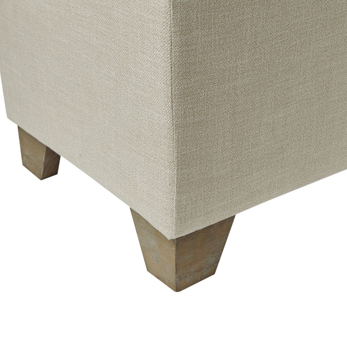 Close-up of Madison Park Jaxon storage ottoman corner and tapered legs