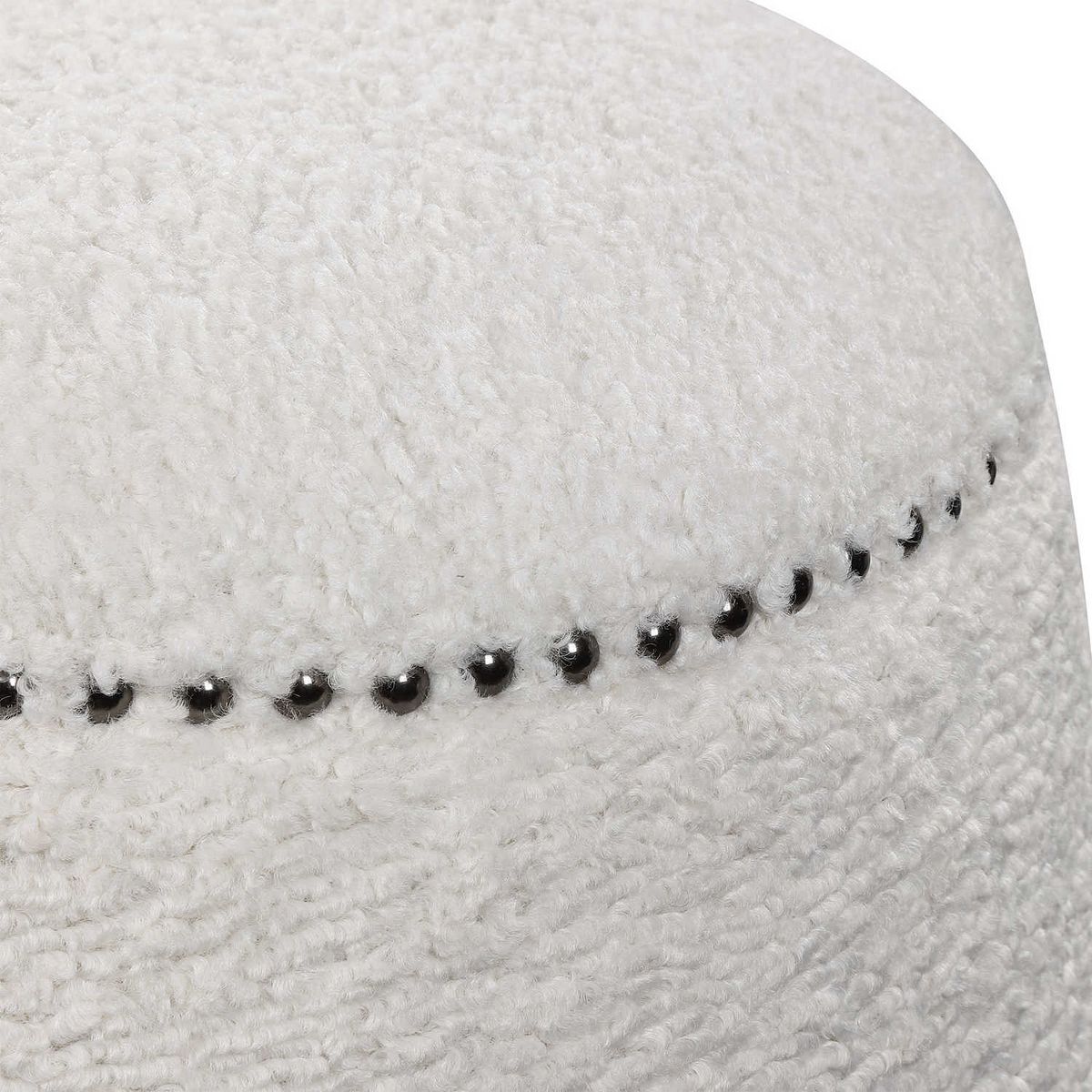 Close-up of white boucle ottoman edge with studded trim