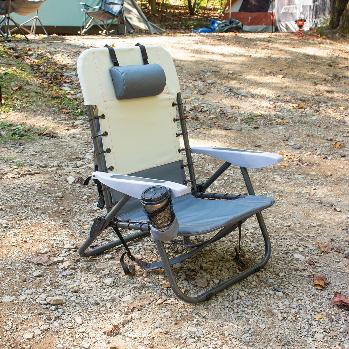 Gray two-tone outdoor folding chair on campground ground.