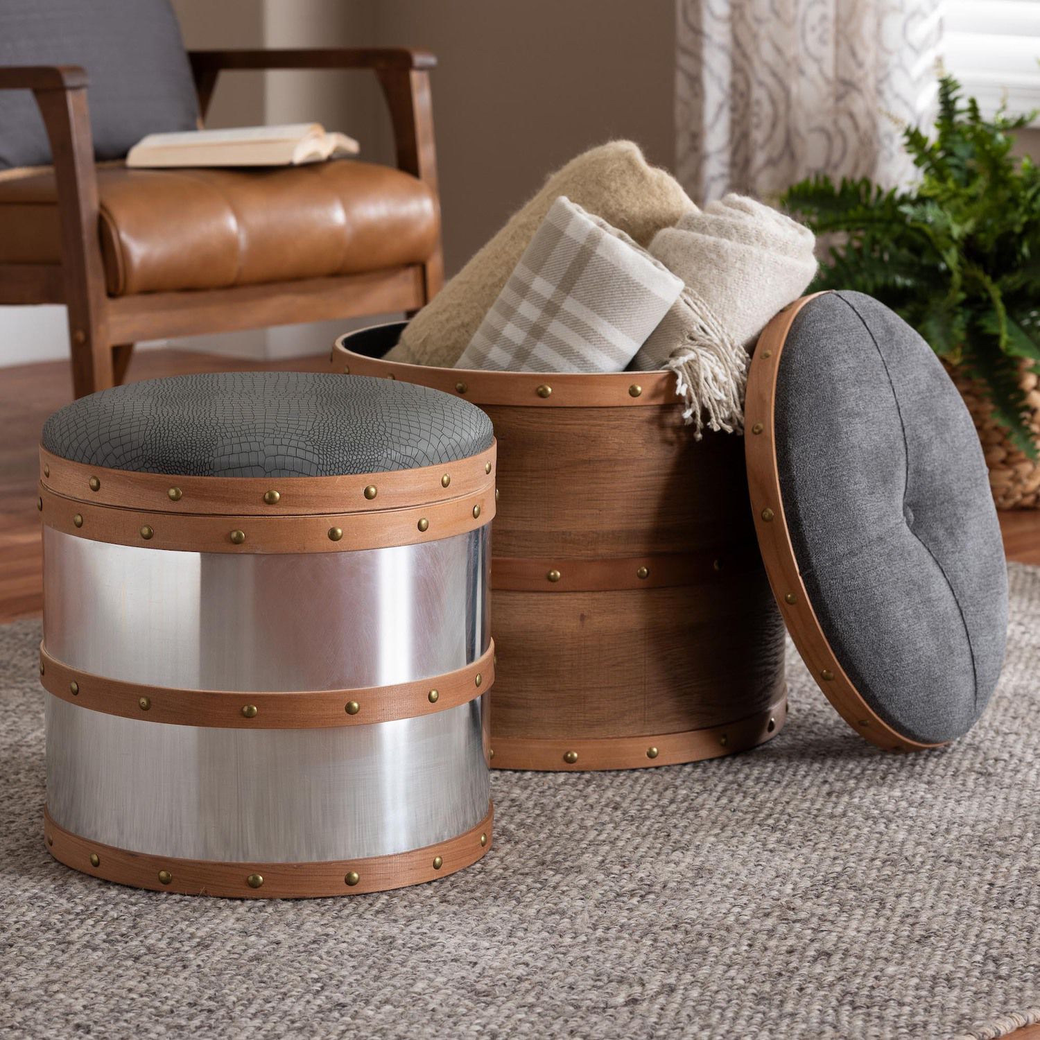 Caleb ottoman with dark gray top and wood-and-metal studded base in living room setting