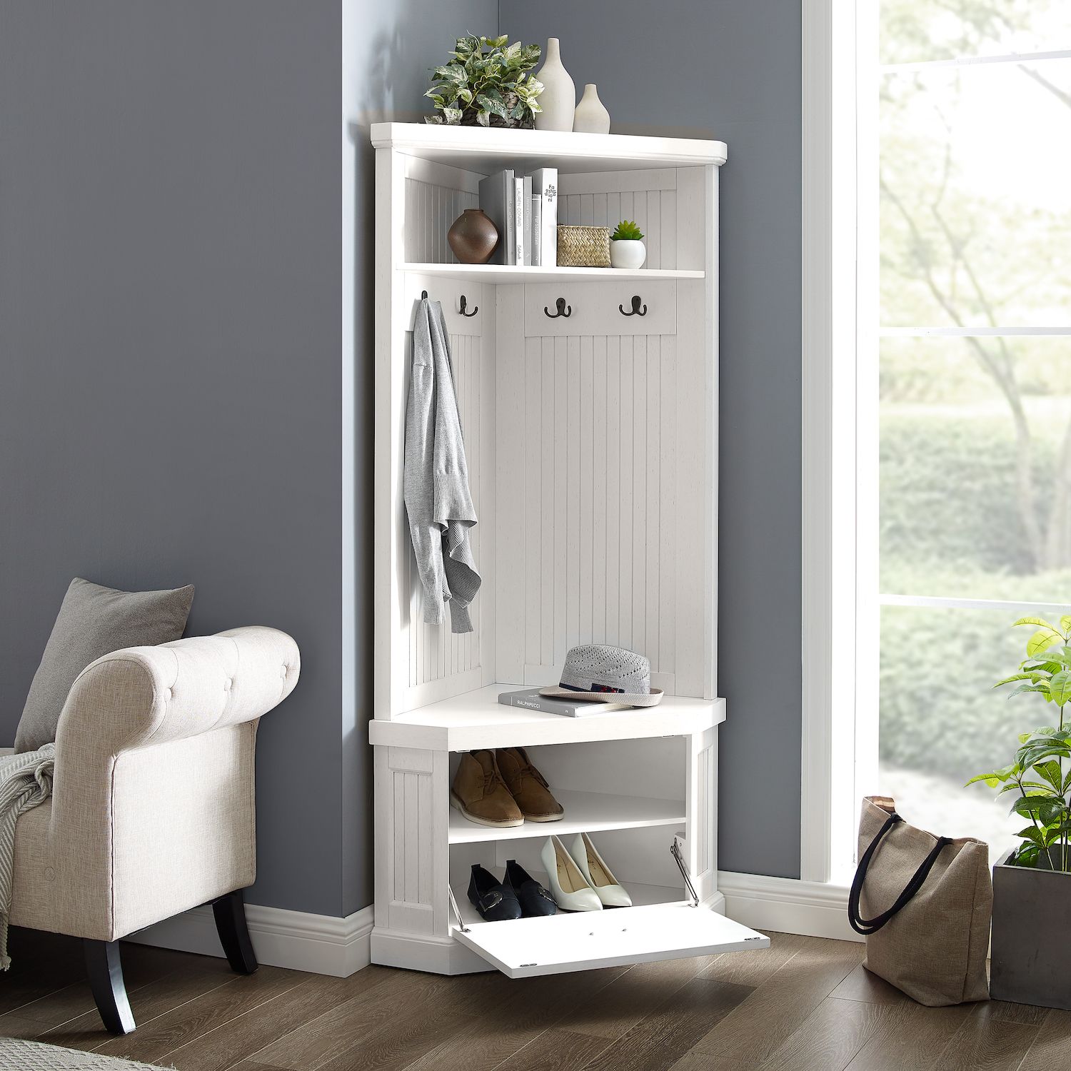 Corner hall tree with white cabinet back and hooks beside a wall