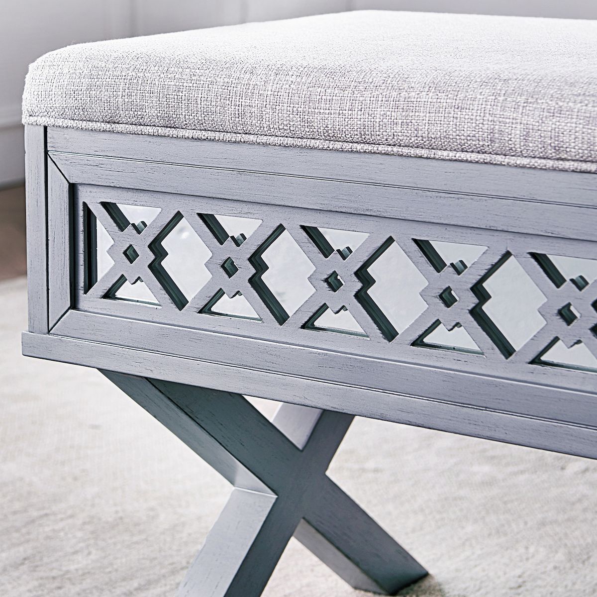 Close-up of mirror diamond cutout panel on a light gray storage bench
