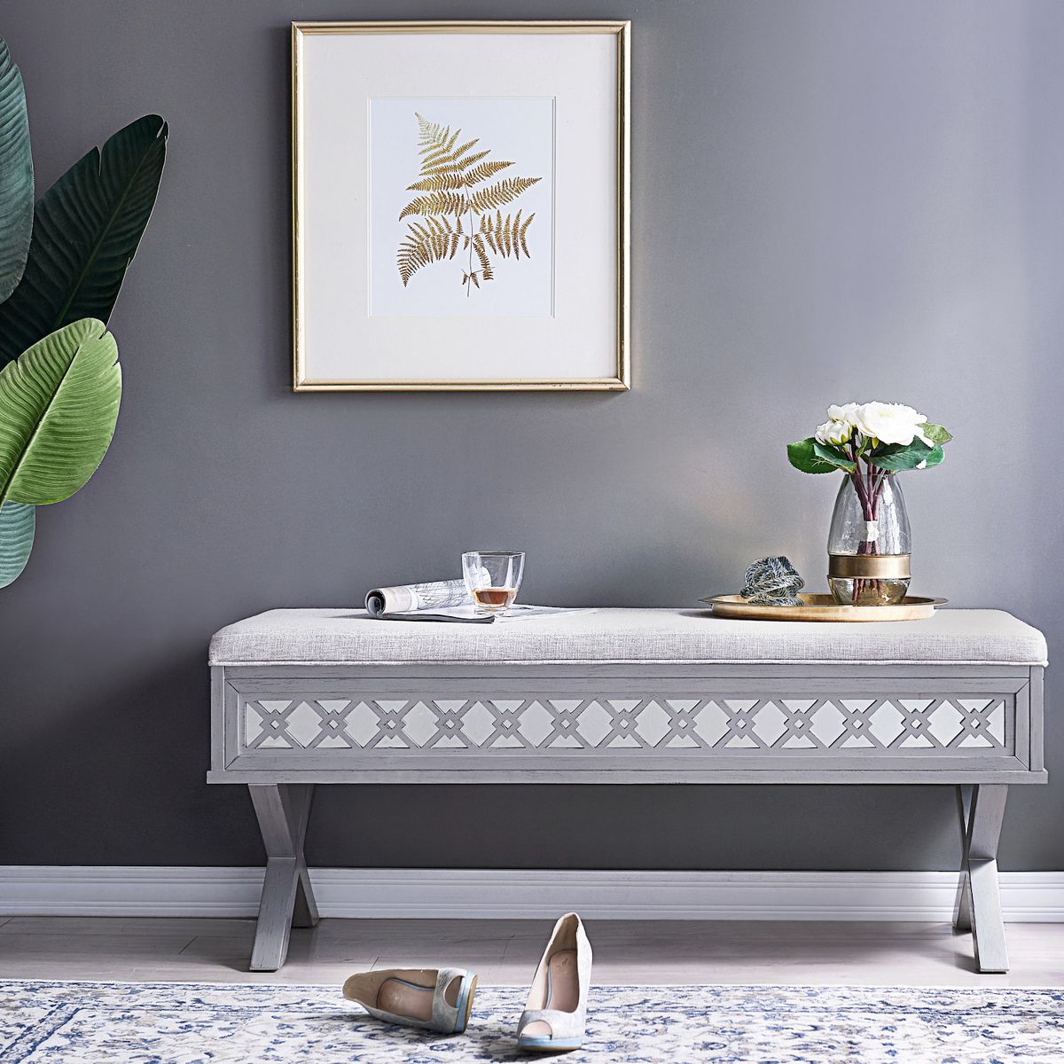 Light gray mirror diamond cutout storage bench on rug with shoes nearby