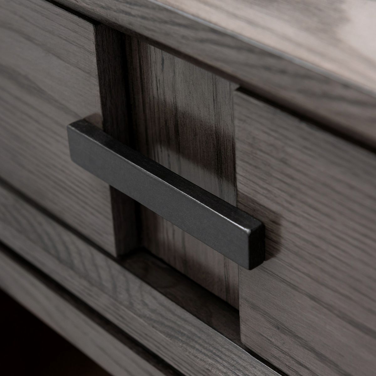 Close-up of smoke gray drawer with dark bar pull on nightstand side table