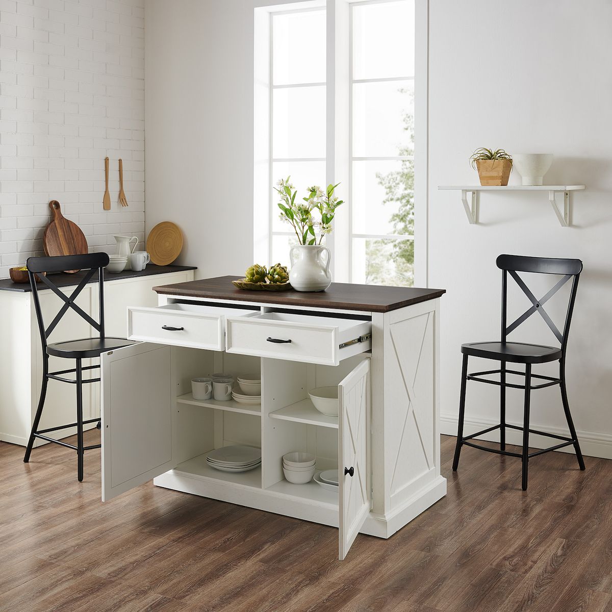 White kitchen island with open storage and two black stools