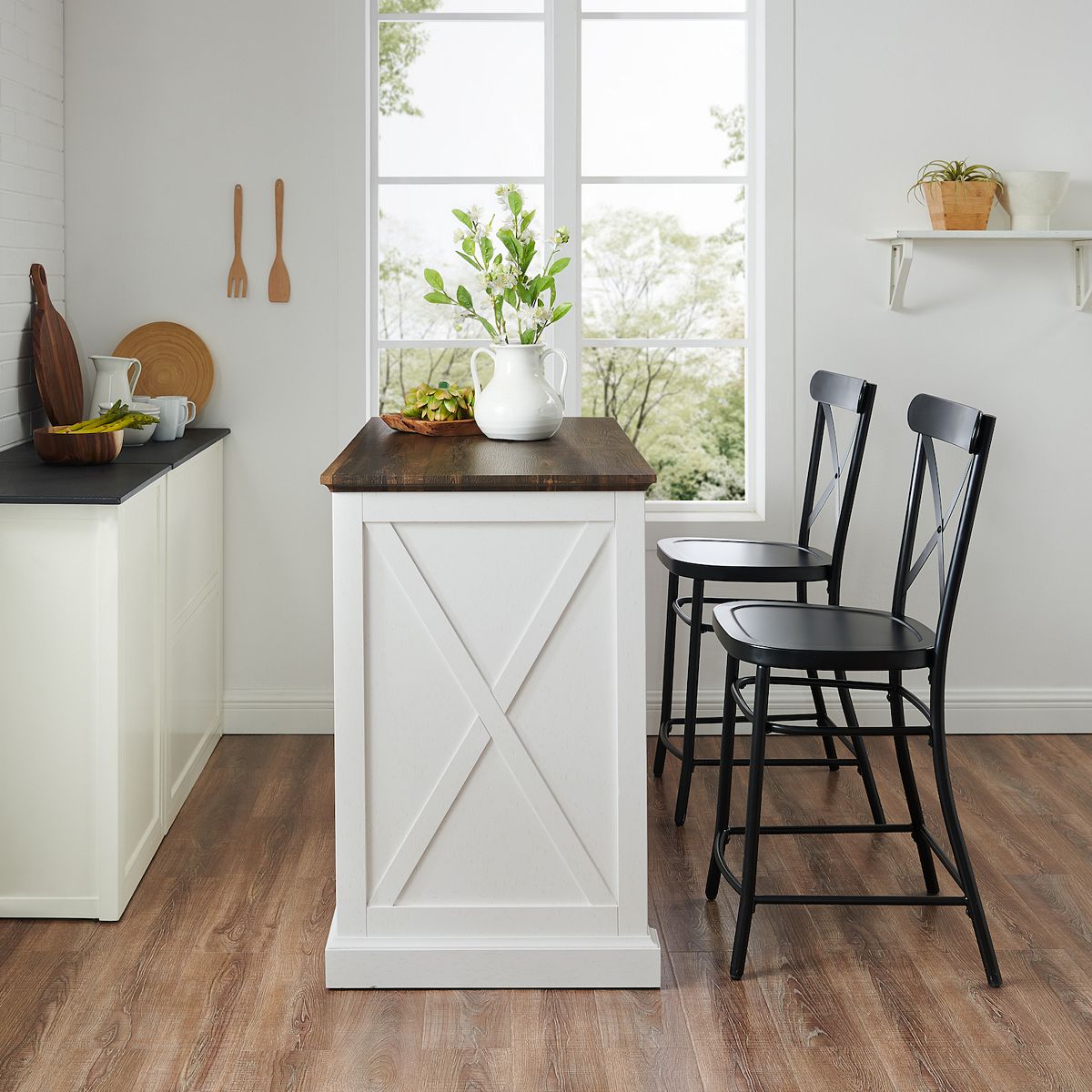 White kitchen island with two black stools near window