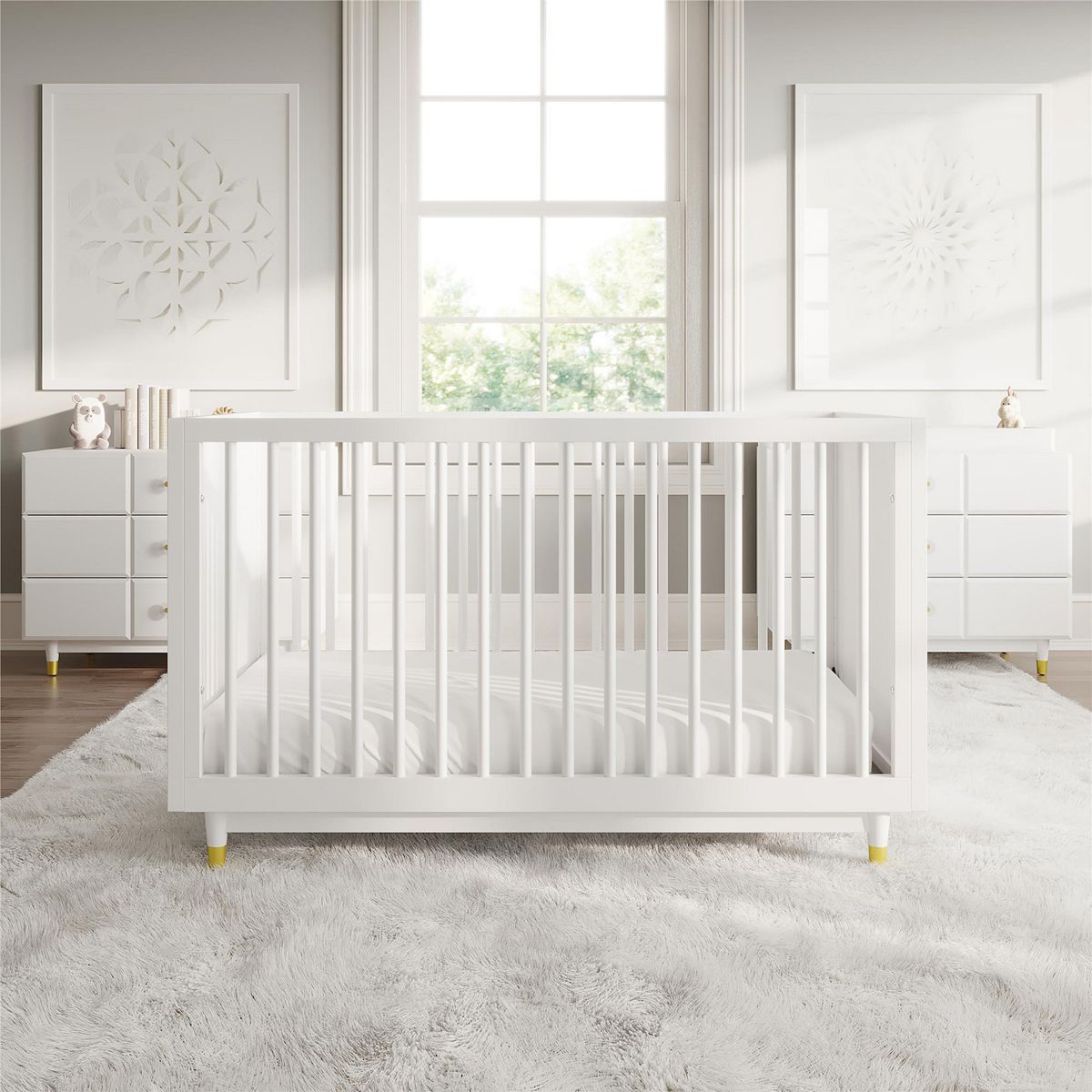 White crib viewed from front with vertical slat rails and gold corner feet