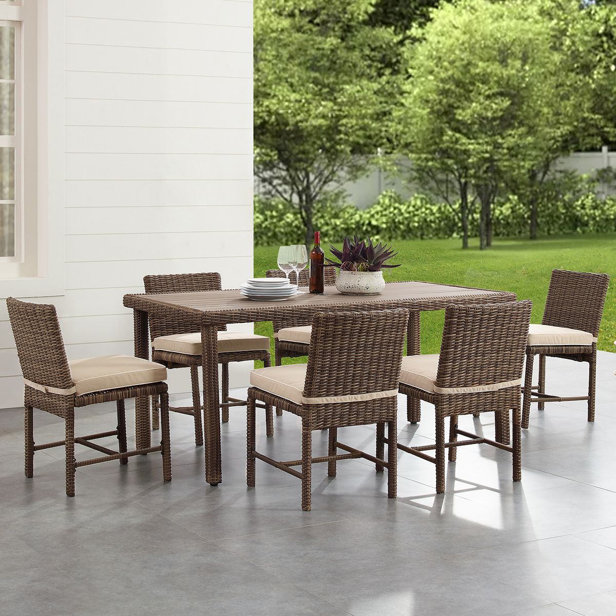 Outdoor wicker dining table and chairs with blue seat cushions