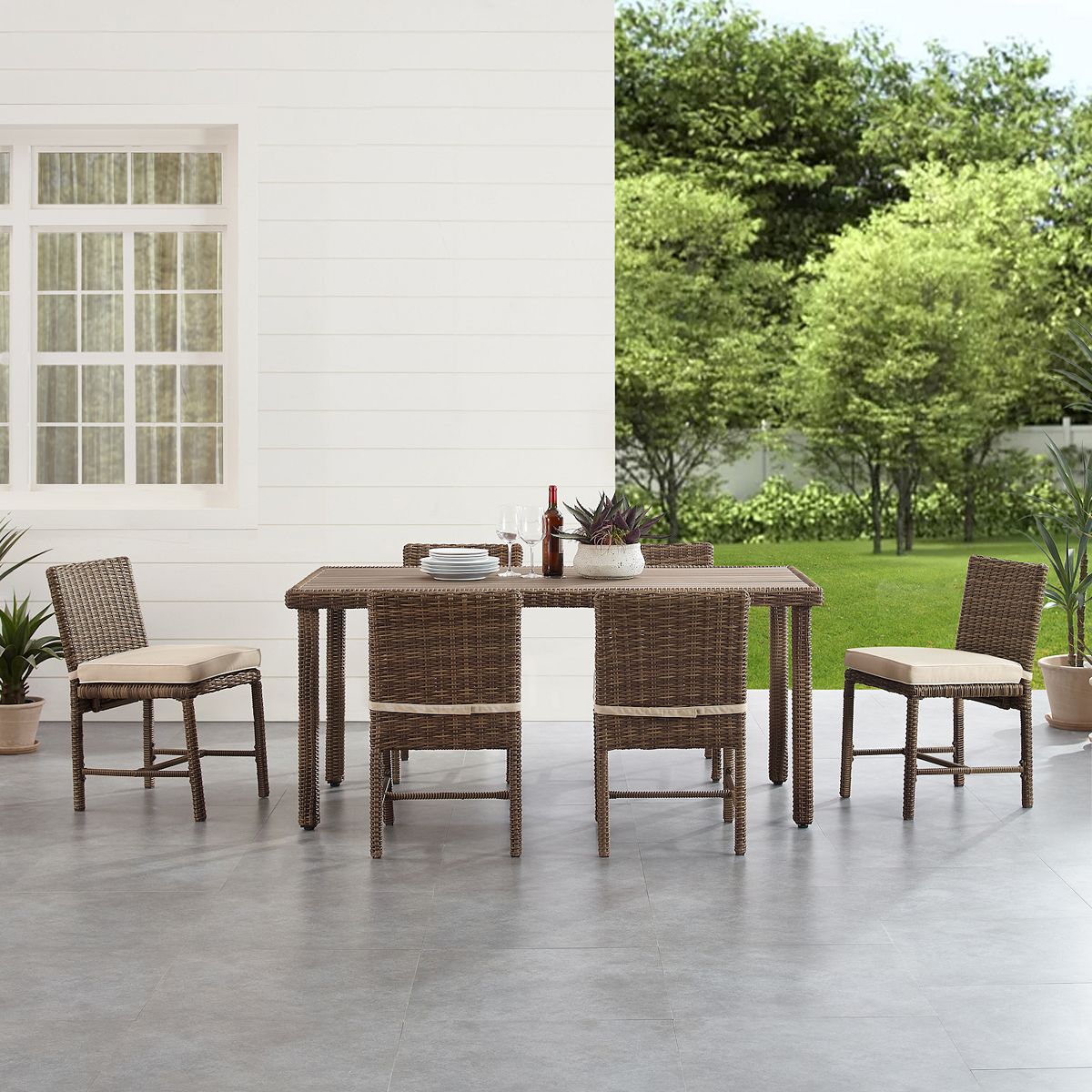 Outdoor wicker dining table with six chairs and blue cushions