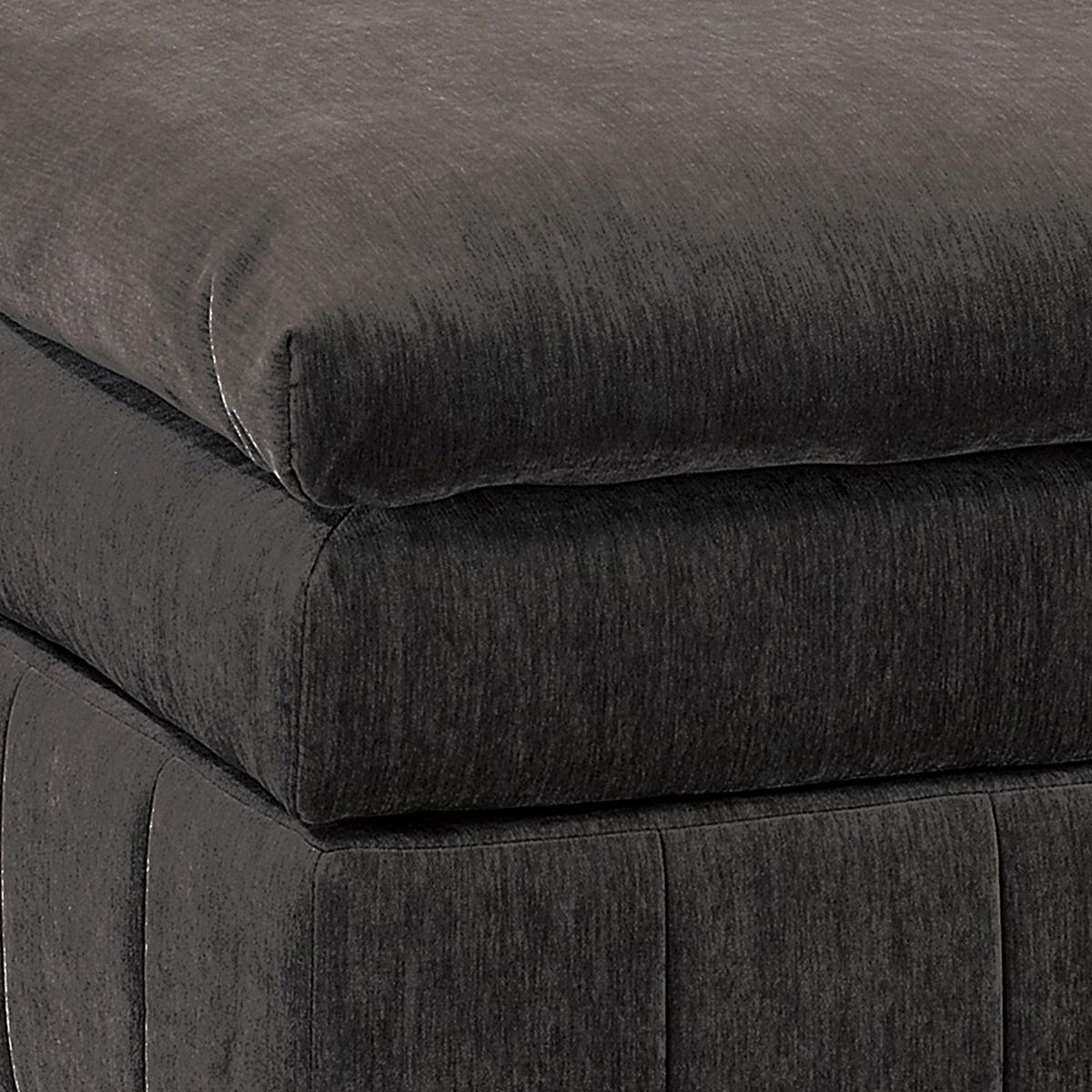 Close-up of dark gray ottoman layered cushions and seam lines.
